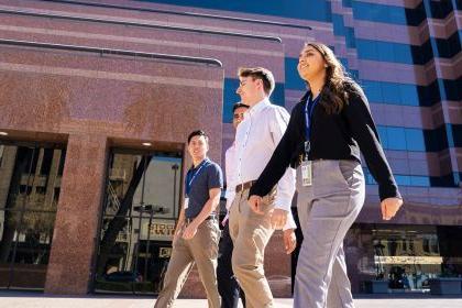 Four students walk in front of Stockton city building